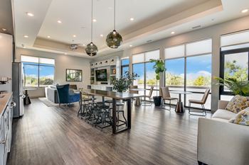 A modern kitchen with a dining area and a view of the outdoors.
